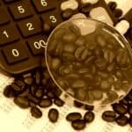 Coffee beans, calculator and magnifying glass in sepia tone, original source: Shutterstock