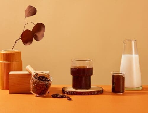 black coffee with plant, coffee beans and milk, source: Shutterstock