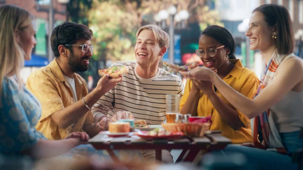 Multiethnic group of people eating outside, source: Shutterstock